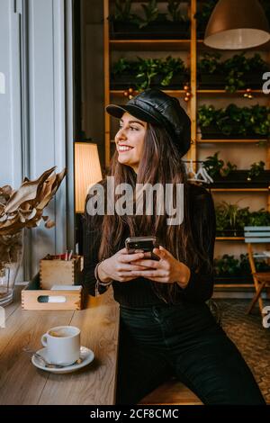 Junge Dame mit Smartphone im Café Stockfoto