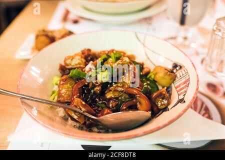 Hoher Winkel der Schüssel mit leckeren traditionellen Ramen und Löffel Platziert auf dem Tisch im japanischen Restaurant Stockfoto