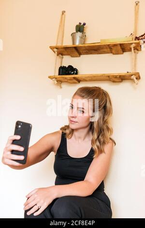 Junge Frau mit Handy zu Hause Stockfoto