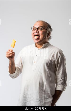 Indischer alter Mann Essen Schokolade Eis in Kegel oder Mango Candy Bar Stockfoto