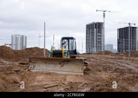 Gleisdozer für Schwimmbadaushub und Versorgungsgräben. Bulldozer während der Grundstücksräumung und Fundamentgraben. Erdbewegliches Schwergerät an der Kon Stockfoto