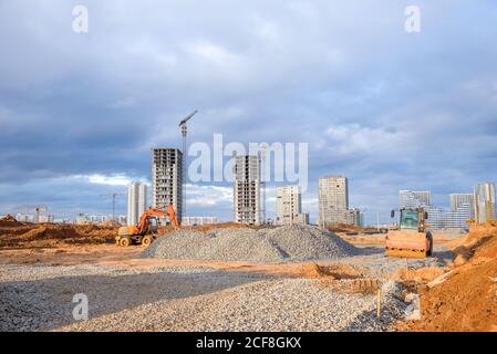 Bagger und Vibration Einzylinder-Straßenwalze beim Bau von Straße und Fundament. Straßenausrüstung zum Nivellieren von Boden, Kies in Straßenarbeiten Stockfoto