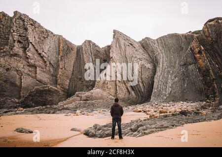 Reifer männlicher Unternehmer mit Tablet, das am Tisch mit Netbook im Büro im Loft-Stil auf dem Handy spricht Stockfoto