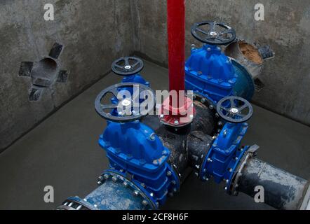 Schieber in der Schiebergrube der Erdleitungsnetze. Verlegung der Wasserleitung auf der Baustelle. Wasserleitung, Rohre in Graben Stockfoto