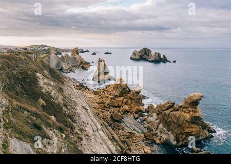 Erstaunliche Luftlandschaft von steilen felsigen Küste und atemberaubende Wellenmeer in bewölkten Tag in Pielagos, Kantabrien, Santander, Spanien Stockfoto