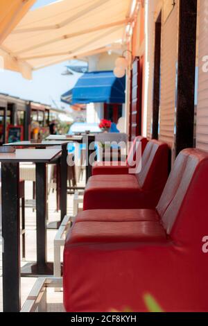 Rote Lederstühle zu zweit in einem kleinen Café an der adria in biograd. Leer am Ende der Sommersaison Stockfoto