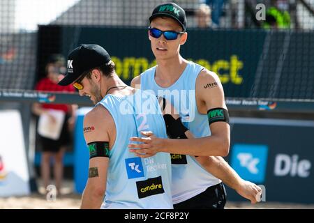 Timmendorfer Strand, Deutschland. September 2020. Die Nationalmannschaft Julius Thole (l) und Clemens Wickler umarmen sich nach einem Sieg in einem Gruppenspiel bei der Deutschen Beachvolleyball-Meisterschaft. Die Meisterschaften, die mit 60000 Euro dotiert sind, finden vom 4. Bis 6. September für Damen- und Herrenmannschaften statt. Kredit: Frank Molter/dpa/Alamy Live Nachrichten Stockfoto