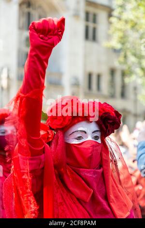 Porträt eines rotgetragenten Protesters während der Extinction Rebellion Demonstration, Parliament Square, London, 1. September 2020 Stockfoto