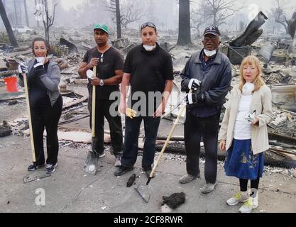 Santa Rosa, USA. August 2020. Das Foto, aufgenommen von einer Tafel, zeigt die Familie Granger im Jahr 2017, Tochter Audrey (l), Sohn Jeff (M), Henry Granger (2. V. r.) und Astrid Granger, in den Überresten ihres abgebrannten Hauses. Im Jahr 2017 verloren sie ihr Haus im Coffey Park-Viertel beim sogenannten Tubbs-Brand in Santa Rosa. (To dpa 'Kalifornien wird zur Feuerhölle - kein Ende in Sicht') Quelle: Barbara Munker/dpa/Alamy Live News Stockfoto