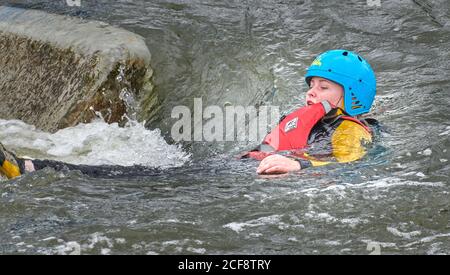 Ein jugendliches Mädchen schwimmt flussabwärts auf ihrem Rücken auf dem künstlichen Wildwasserkurs von Nene, Northampton, England. Stockfoto