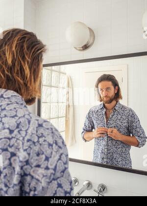 Handsome männlich Überprüfung Frisur im Spiegel Reflexion Stockfoto