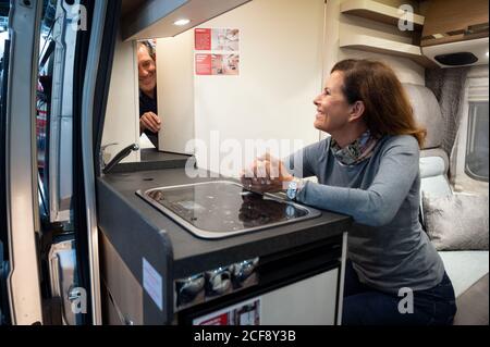 04. September 2020, Nordrhein-Westfalen, Düsseldorf: Die Modelle Ingo und Gaby sitzen im Malibu-Van während der Pressetour zur Messe Caravan Salon 2020, die ihr neues Konzept "First Class - Two Rooms" präsentiert. Der Hersteller versteht dies als die Möglichkeit, die Badezimmertür zu verwenden, um den Durchgang zwischen Wohn- und Schlafbereich zu trennen. Der Caravan Salon, die größte Messe in Deutschland seit den Einschränkungen der Corona-Pandemie, hat nach Angaben der Messebranche am Freitag begonnen. Maximal 20,000 Besucher pro Tag dürfen die Stände von besuchen Stockfoto