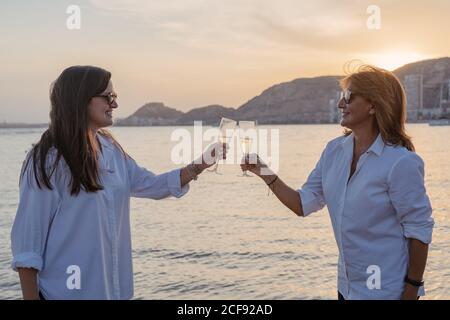 Mutter und junge Tochter klirren Gläser Wein und lachen Wir feierten ein Familientreffen am Abend im Resort Stockfoto