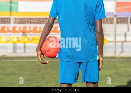 Schwarzer Fußballspieler mit Ball im Stadion Stockfoto