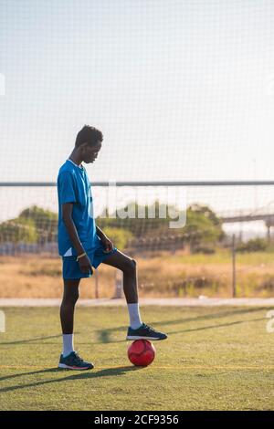 Schwarzer Fußballspieler mit Ball im Stadion Stockfoto