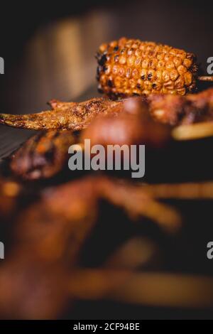 Köstliche gegrillte heiße Spieße mit natürlichem Mais, gesunden Pilzen und Fleisch auf dem Tisch im Restaurant Stockfoto