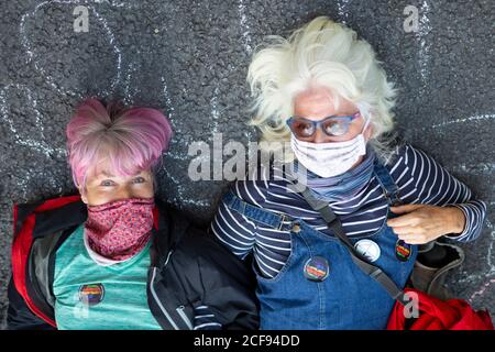 Zwei weibliche Demonstranten blockieren Straße während der Rebellion-Demonstration des Aussterbens, Parliament Square, London, 1. September 2020 Stockfoto