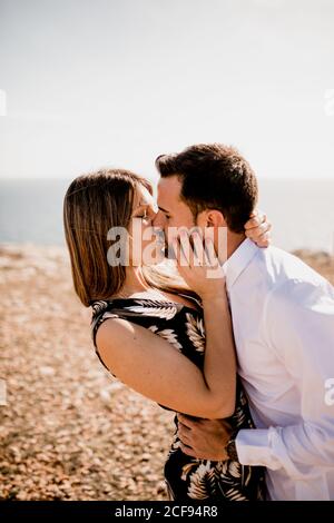 Seitenansicht einer leidenschaftlichen Frau und eines Mannes, die sich im Sommer zärtlich auf die Natur küssen Stockfoto