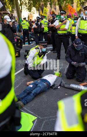 Polizeigespräch mit einem Protestierenden, der während der Extinction Rebellion Demonstration eine Straße blockiert, Parliament Square, London, 1. September 2020 Stockfoto