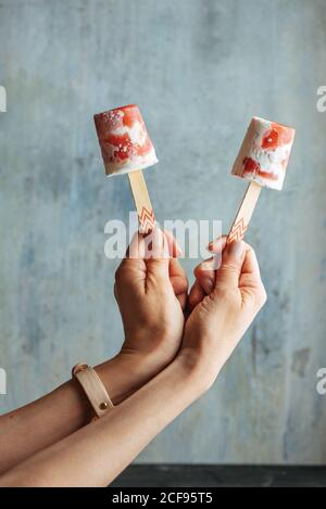 Frau Hände halten zwei Wassermelone und Sahne-Eis-Eis-Eis gegen Licht Blauer Hintergrund Stockfoto