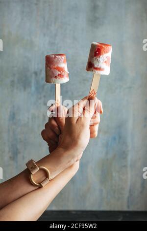 Frau Hände halten zwei Wassermelone und Sahne-Eis-Eis-Eis gegen Licht Blauer Hintergrund Stockfoto