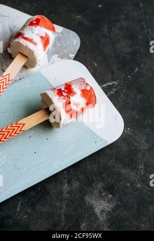 Draufsicht auf zwei Wassermelonen und cremige Eiszapfen Schicke Gerichte auf dunklem Hintergrund Stockfoto