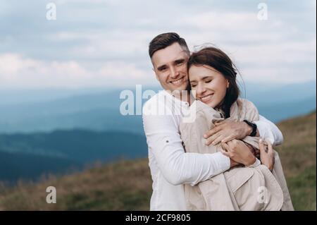 Brautpaar kuscheln vor der Kulisse der Berge. Stockfoto