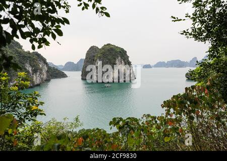 Kreuzfahrt Junk oder Boot, die neben einer der Kalksteininseln oder Kalksteinkarsten, Hạ Long Bay, Vietnam, Asien festgemacht sind Stockfoto