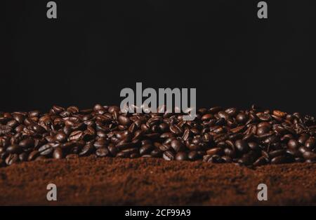 Fallend frisch gerösteten Kaffeebohnen und Pulver Kaffee isoliert auf Schwarzer Hintergrund Stockfoto