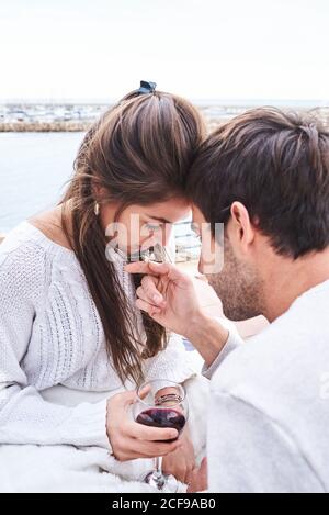 Von oben Seitenansicht des liebevollen zärtlichen jungen Paares umarmt Und küssen, während romantische Momente zusammen Stockfoto