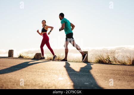 Fitnesspaar, das auf der Straße läuft. Athleten trainieren gemeinsam für einen Marathon. Stockfoto