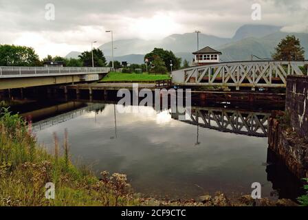 Banavie Drehbrücken über den Caledonischen Kanal. Die Eisenbahnbrücke auf der rechten Seite wird gerade geöffnet, damit eine Yacht durchfahren kann. Stockfoto