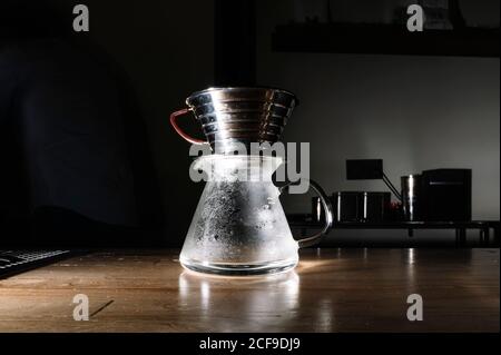 Glaskrug und Metallbecher auf Holztheke in platziert Café-Bar für die Zubereitung von chemex-Getränken Stockfoto
