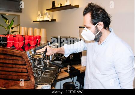 Seitenansicht der Barista-Reinigungskaffeemaschine im Café Stockfoto