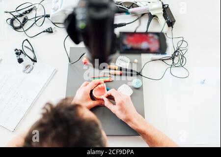 Von oben der Ernte anonyme Zahnmedizin Student hält Prothese während Ausbildung Fähigkeiten in modernen Labor Stockfoto