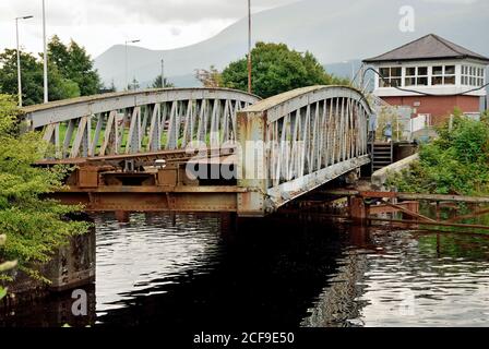 Banavie Eisenbahnschwingenbrücke über den Caledonischen Kanal. Die Brücke wird hier im Prozess der Schließung gesehen, nachdem eine Yacht durchfahren kann. Stockfoto