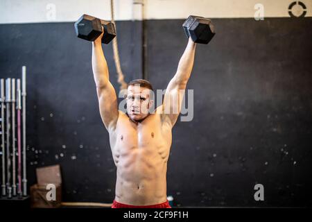 Mann mit Hanteln trainieren Stockfoto