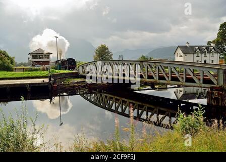 Die Jacobite Dampfzug über Banavie Railway Schaukelbrücke, auf dem Weg nach Mallaig. Stockfoto