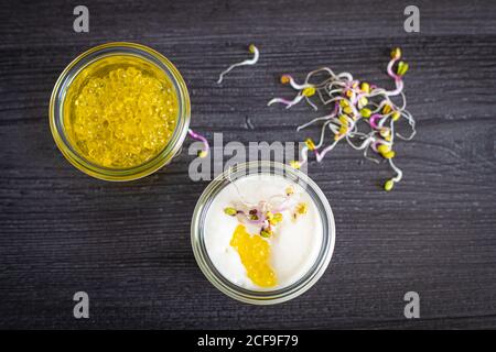 Von oben gesunde leckere Mousse von Ziegenkäse, karamellisierte Zwiebel und extra natives Olivenöl Kaviar in Glasschüssel auf grauem Hintergrund Stockfoto