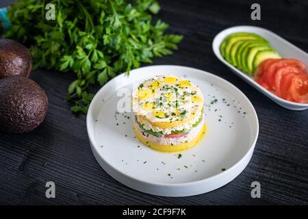Von oben lecker appetitlich Lima Ursache von Thunfisch mit dekoriert Grüne und geschnittene Tomaten Avocado in weißen Tellern auf dem Tisch Stockfoto