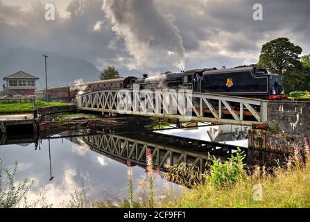 Die Jacobite Dampfzug über Banavie Railway Schaukelbrücke, auf dem Weg nach Mallaig. (Als HDR-Bild verarbeitet). Stockfoto