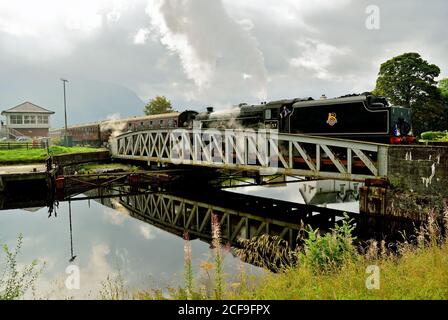 Die Jacobite Dampfzug über Banavie Railway Schaukelbrücke, auf dem Weg nach Mallaig. Stockfoto