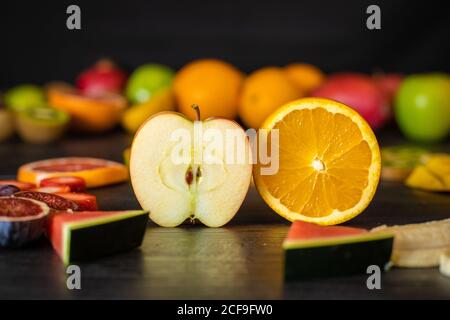 Verschiedene geschälte und schneiden gesunde Früchte und Gemüse auf angeordnet Ein schwarzer Holztisch Stockfoto