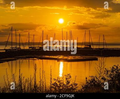 golden Sonnenuntergang Sonne reflektiert auf See Champlain in Burlington, Vermont auf der Marina mit Segelbooten Stockfoto