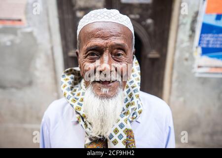 Bangladesch - Januar, 25 2019: Ältere ethnische Männer in traditioneller Kopfbedeckung lächeln und schauen auf die Kamera auf der Straße Stockfoto