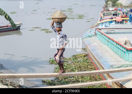 Lokale ethnische Menschen entladen Fisch aus dem Boot nach dem Angeln in Barisal in Bangladesch Stockfoto