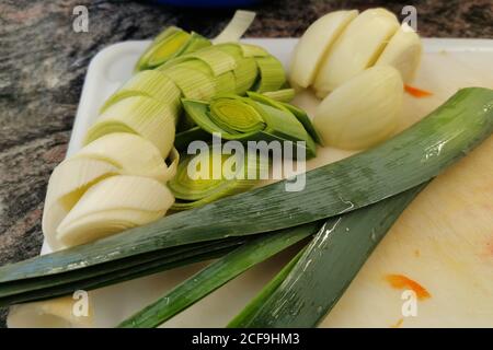 Nahaufnahme der gehackten grünen Zwiebel für Salat gekocht liegt auf dem Brett. Stockfoto