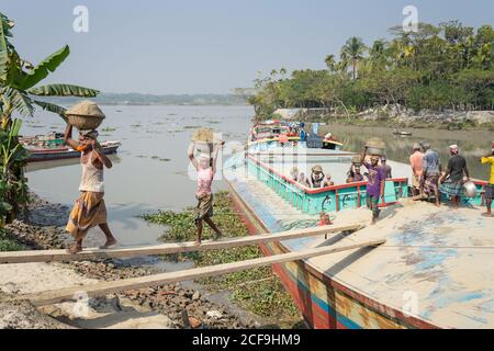 Lokale ethnische Menschen entladen Fisch aus dem Boot nach dem Angeln in Barisal in Bangladesch Stockfoto