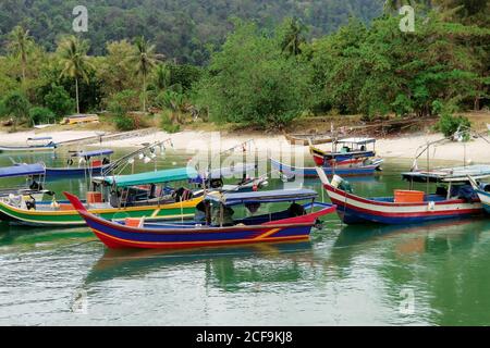 Bunte Boote dockten am tropischen Strand an Stockfoto