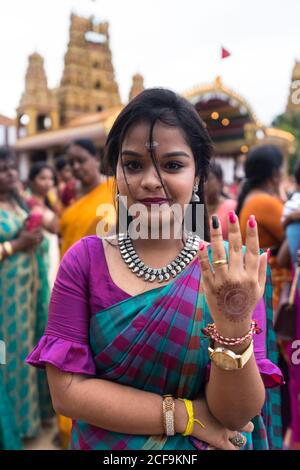 Jaffna, Sri Lanka - 9. August 2019: Junge tamilische Frau in farbenfrohen traditionellen Kleidern, die während des Nallur Kandaswamy Kovil Festivals vor der Kamera stehen Stockfoto